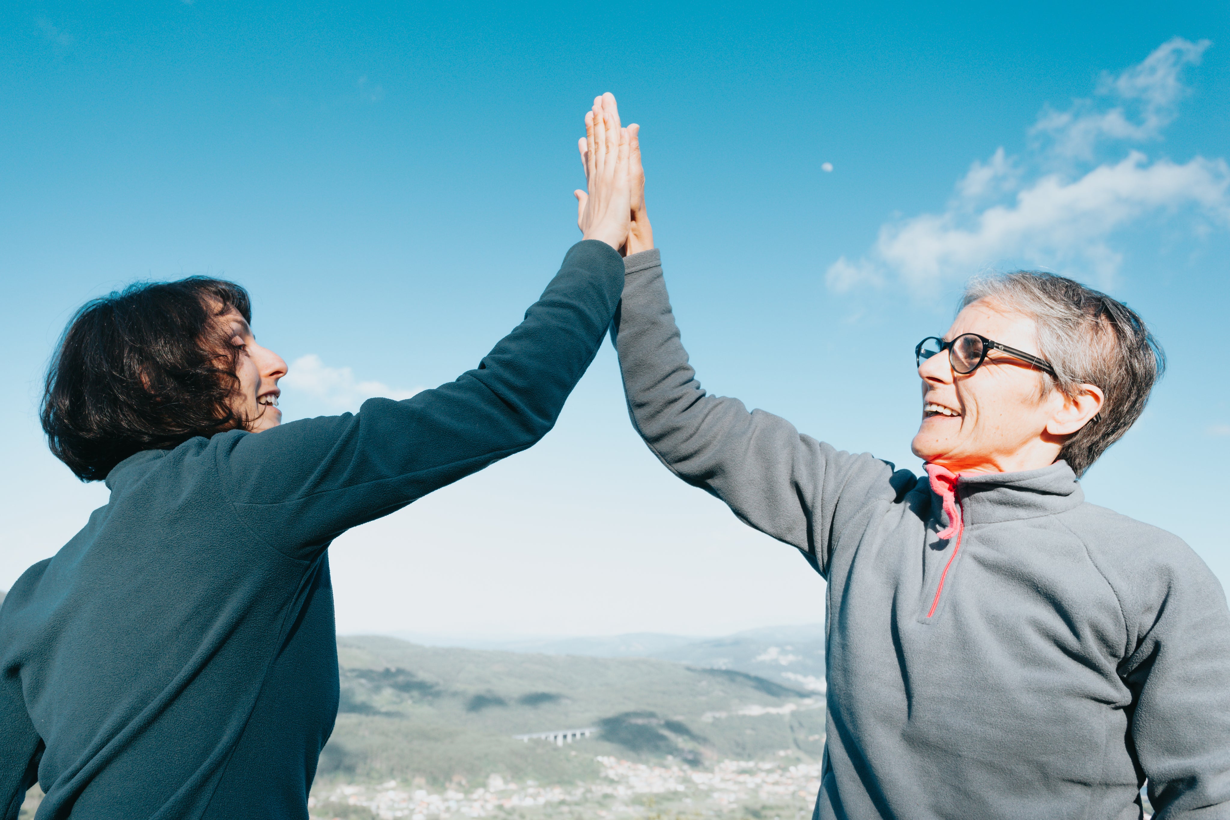 files/two-woman-high-fiving-under-blue-sky.jpg